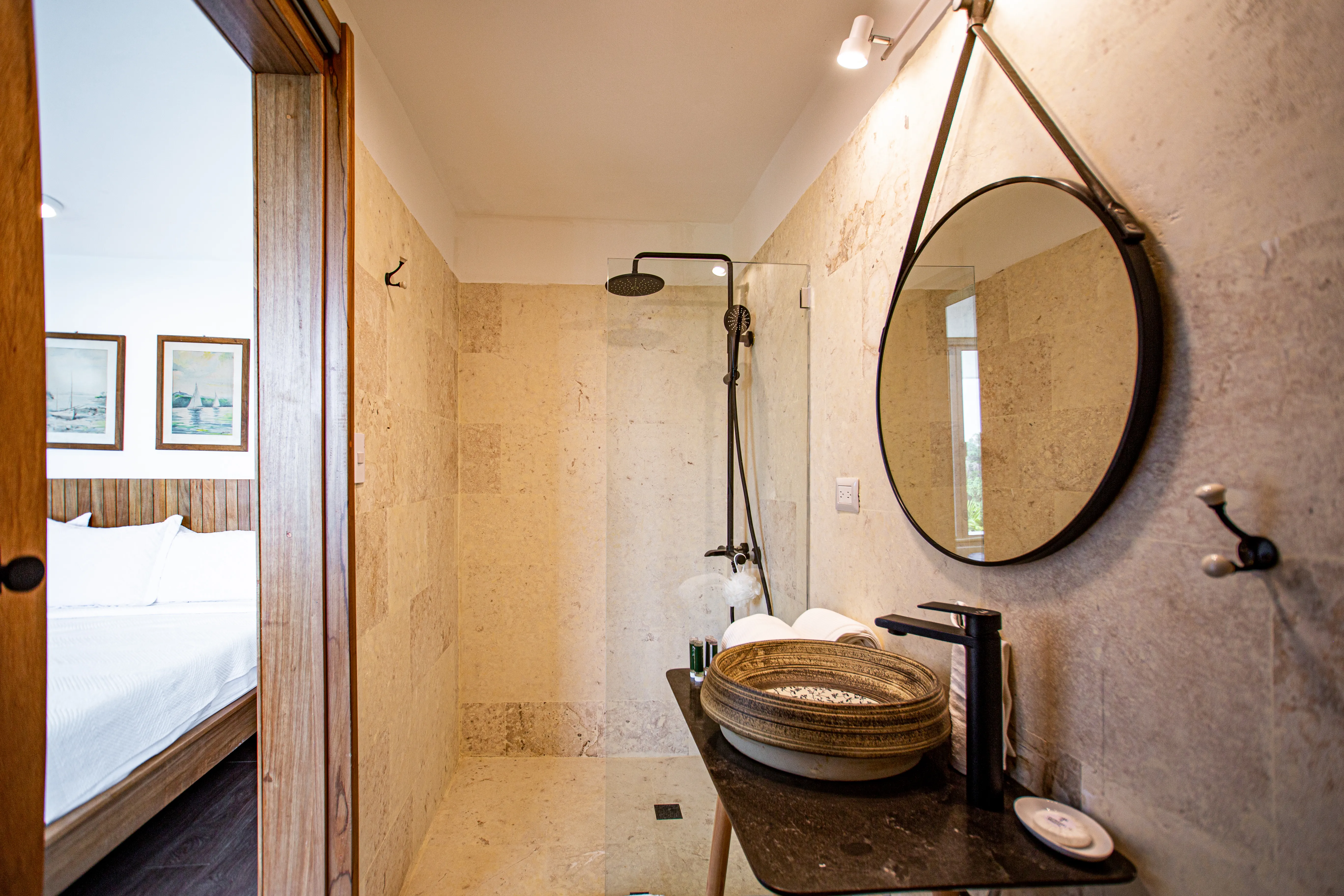 Bedroom 2 ensuite with a stone walk-in shower and round mirror