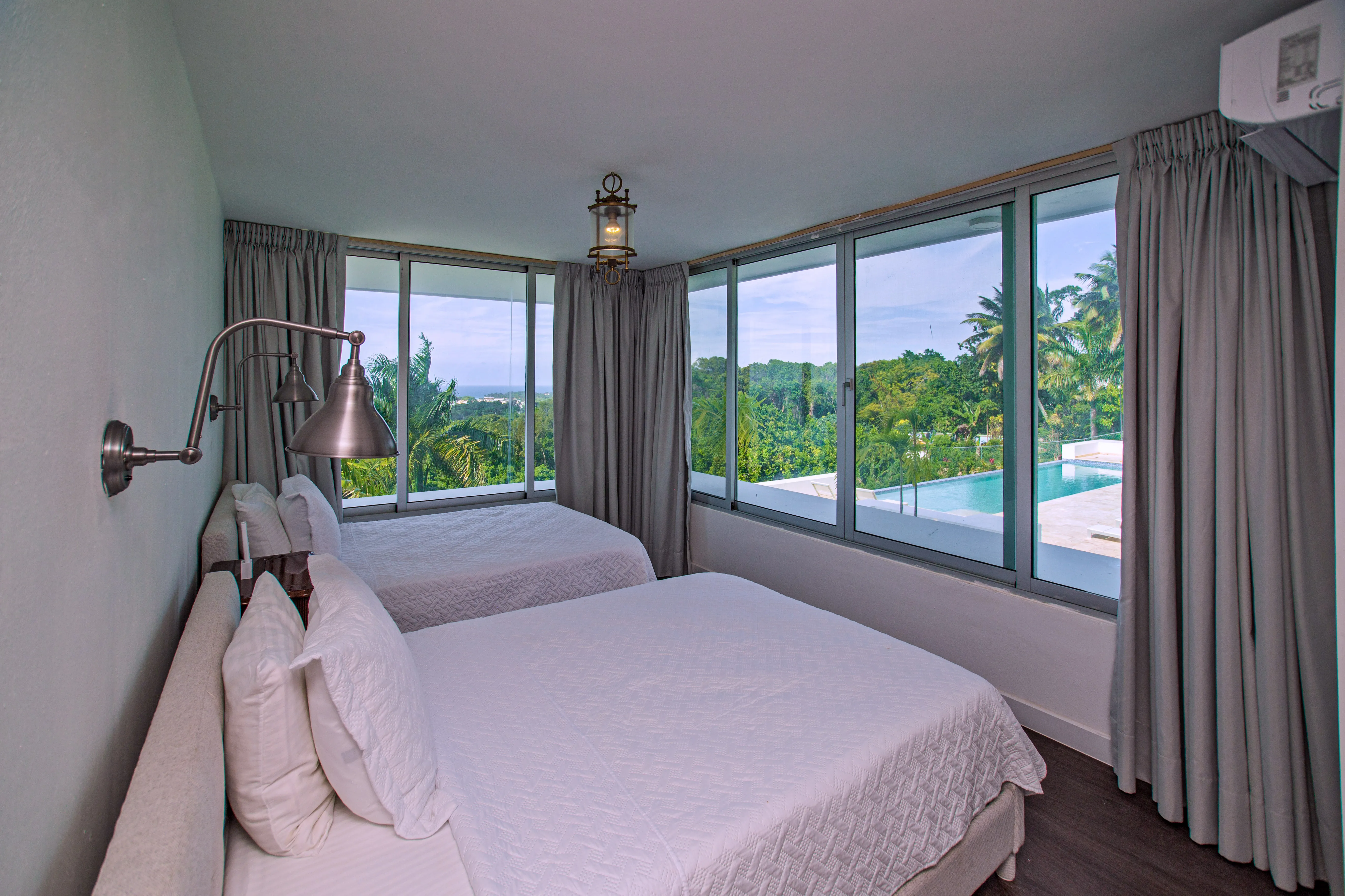 Two-bed room with corner windows over the pool and ocean