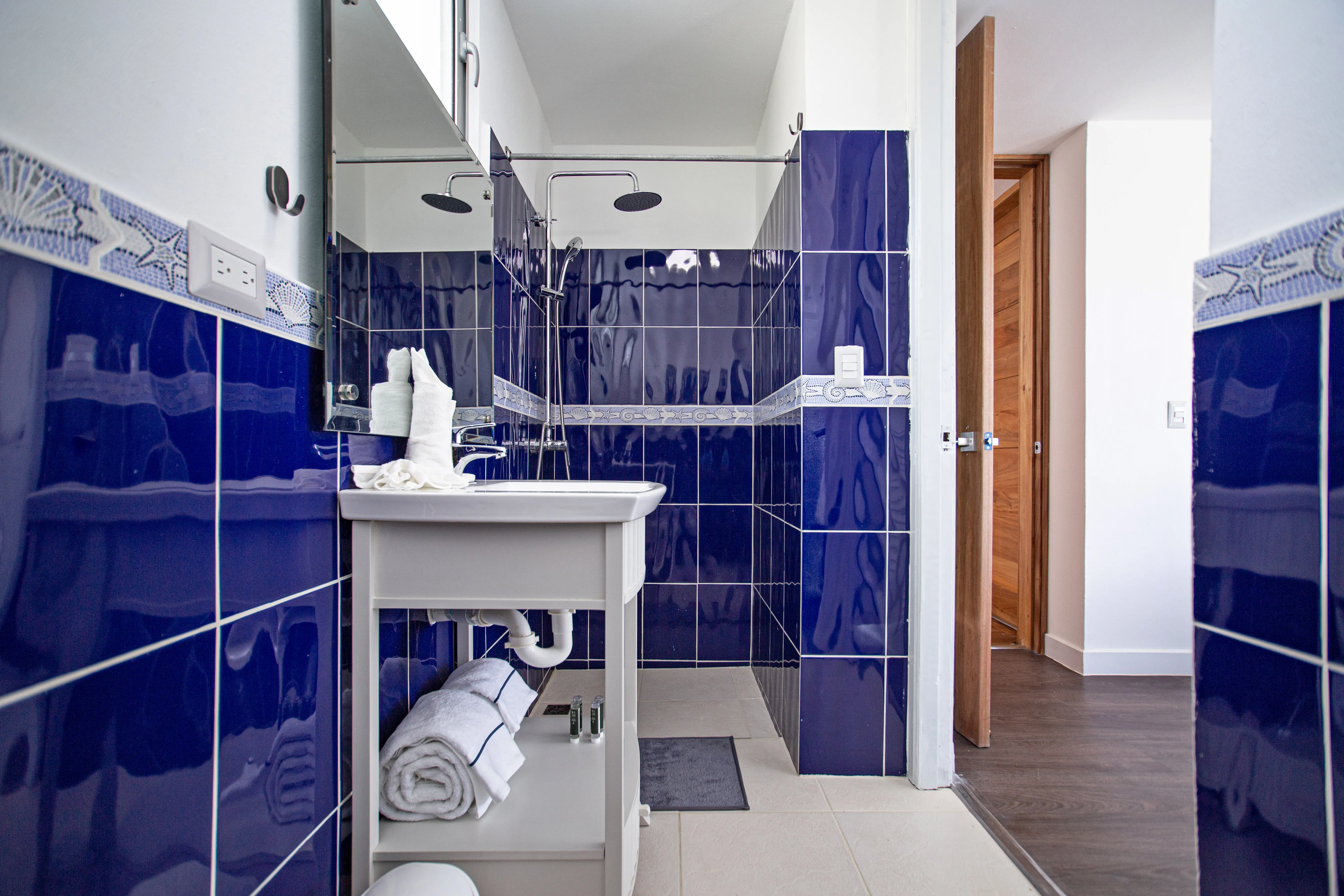 Bedroom 4 ensuite with cobalt-tiled walls and a walk-in shower