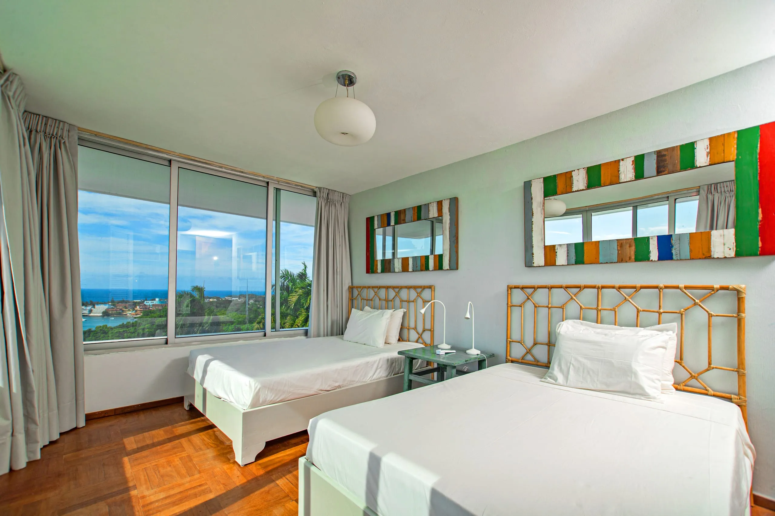 Twin-bed room with coastal artwork and an ocean view